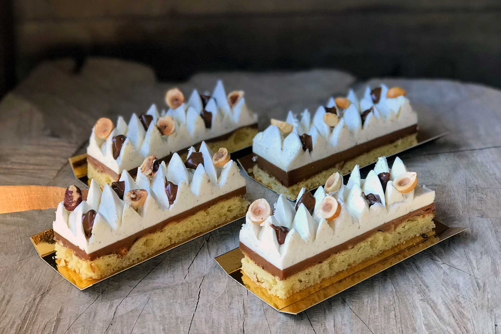 Pâtisserie composée d'une ganache vanille chocolat blanc, gâteau de Gênes, crémeux noisette.