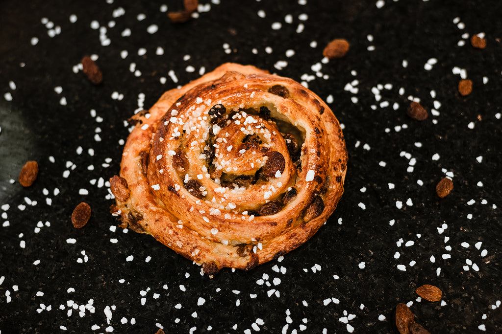 Le roulé aux raisins ou "pain aux raisins" est une viennoiserie composée de pâte feuilletée, crème pâtissière et raisins secs.